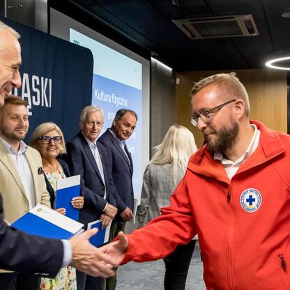 Wicemarszałek Leszek Pietraszek wita laureatów konkursu odsłon kultury fizycznej i bezpieczeństwa publicznego na Stadionie Śląskim. (wygenerowano przez AI)