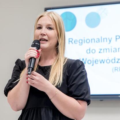 Joanna Bojczuk, członek Zarządu Województwa Śląskiego, przemawia na konferencji o planie adaptacji do zmian klimatu. (wygenerowano przez AI)