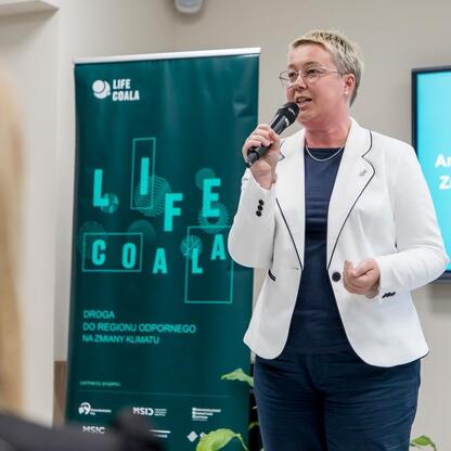 Aneta Esnekier, zastępca burmistrza Mikołów, prezentuje Regionalny Plan Adaptacji do zmian klimatu. (wygenerowano przez AI)
