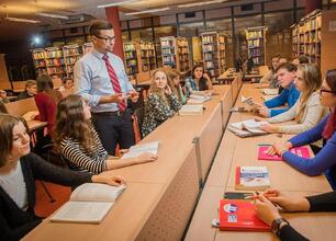 W bibliotece Śląska studenci uczestniczą w dyskusji prowadzonej przez nauczyciela. (wygenerowano przez AI)