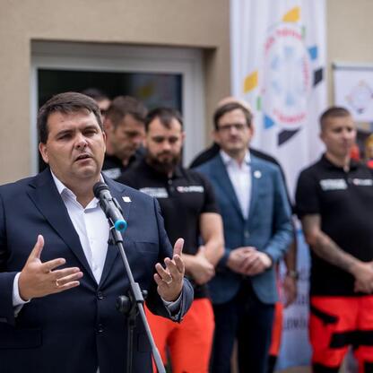 Wicemarszałek Leszek Pietraszek przemawia na konferencji prasowej o modernizacji Rudzkiego Pogotowia Ratunkowego. (wygenerowano przez AI)