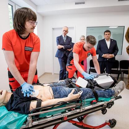 W trakcie szkolenia w nowoczesnym Rudzkim Pogotowiu Ratunkowym w Ruda Śląska, wicemarszałek Leszek Pietraszek i wojewoda Śląskiego Marek Wójcik obserwują trening CPR. (wygenerowano przez AI)