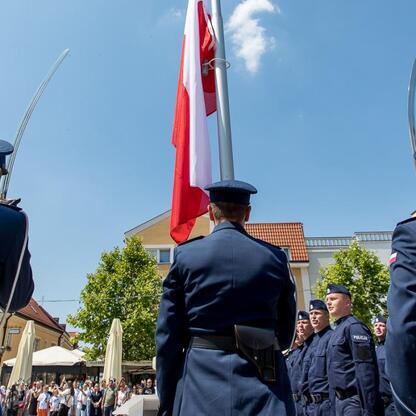 W czasie uroczystości Święta Policji w Rybniku, policjanci w mundurach stoją w formacji, ciesząc się honorowym powitaniem. (wygenerowano przez AI)