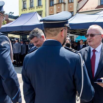 Rybnicki rynek, uroczystości z okazji Święta Policji, policjanci w mundurach i odbiorca nagrody. (wygenerowano przez AI)