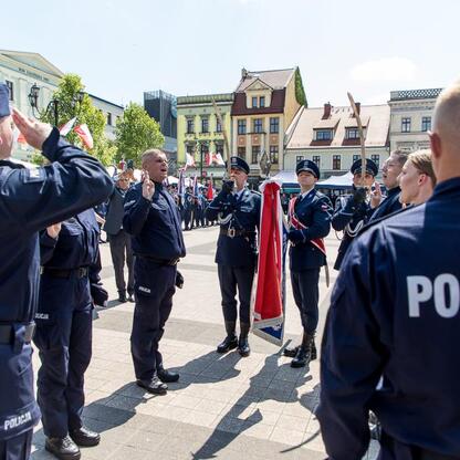 Rybnicki rynek, uroczystości z okazji Święta Policji, salutujące mundurowi, marszałek Saługa, wojewoda Wójcik, parlamentarzyści, odznaczenia, nowi policjanci. (wygenerowano przez AI)
