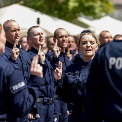 Grupa policjantów w mundurach z napisem 