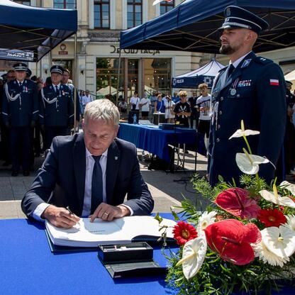 Wojciech Saługa, Marszałek Województwa Śląskiego, podpisuje dokument na Święcie Policji w Rybniku. (wygenerowano przez AI)