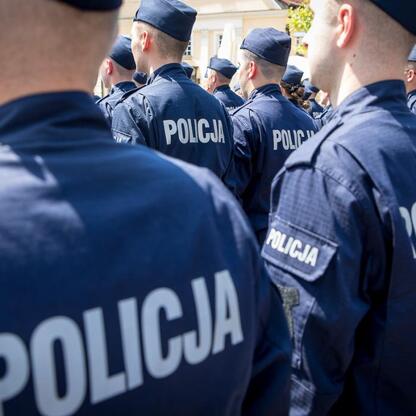 Grupa policjantów w mundurach z napisem 