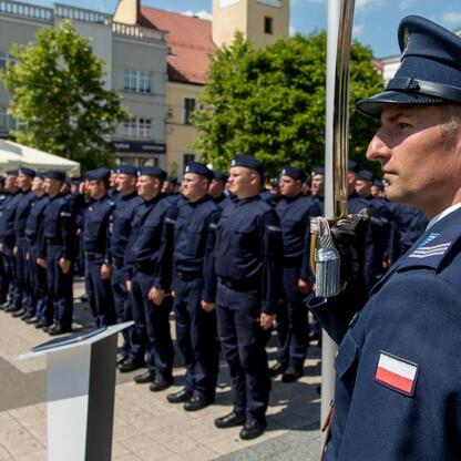 Formalna uroczystość na rynku w Rybniku, gdzie policjanci w mundurach salutują, z okazji Święta Policji. (wygenerowano przez AI)