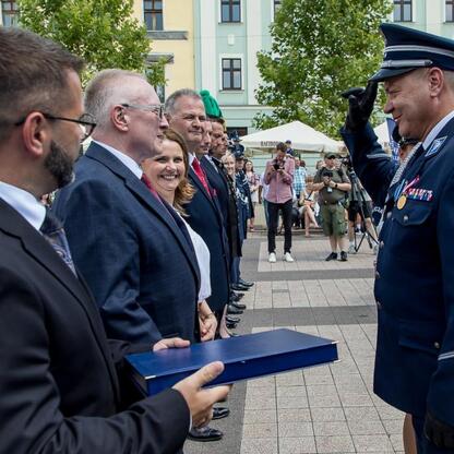 Na Święcie Policji w Rybniku, policjant otrzymuje nagrodę, podczas uroczystości zorganizowanych w 2023 roku. (wygenerowano przez AI)