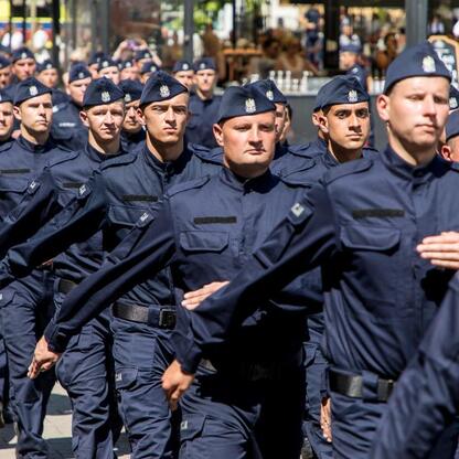 Grupa policjantów w mundurach marszu na placu publicznym podczas Święta Policji w Rybniku. (wygenerowano przez AI)