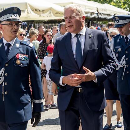 Wojciech Saługa, Marszałek Województwa Śląskiego, spaceruje obok policjantów podczas uroczystości Święta Policji w Rybniku. (wygenerowano przez AI)