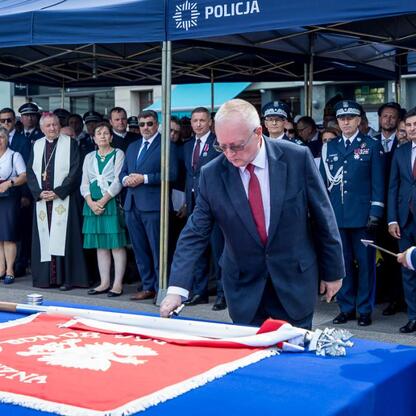 Na rynku w Rybniku odbyła się uroczystość Święta Policji, gdzie marszałek Wojciech Saługa i inny urzędnik składają hołd policjantom. (wygenerowano przez AI)