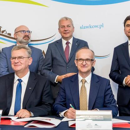 Wojciech Saługa, Rafał Adamczyk i Jerzy Mirgos podpisują dokumenty na ceremonii w Sławkowie, związanej z budową nowego połączenia drogowego. (wygenerowano przez AI)