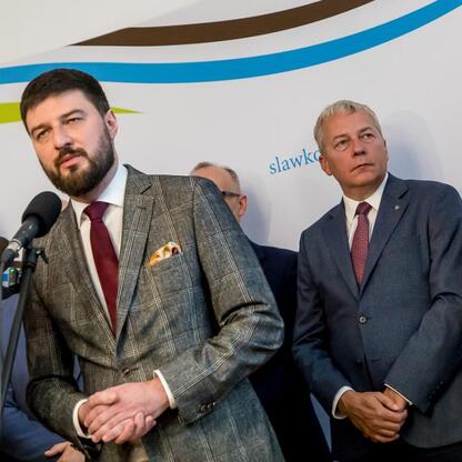 Wojciech Saługa, Marszałek Województwa Śląskiego, oraz Rafał Adamczyk, burmistrz Sławkowa, uczestniczą w konferencji prasowej, podkreślając znaczenie największej inwestycji w historii miasta. (wygenerowano przez AI)