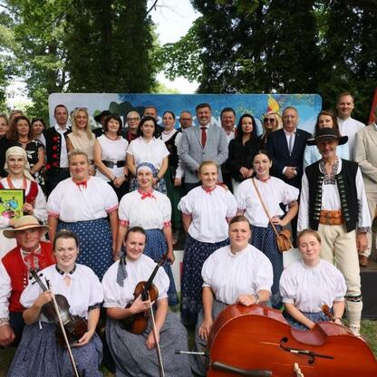 Grupa ludzi w tradycyjnych strojach festiwalowych na Tydzień Kultury Beskidzkiej. (wygenerowano przez AI)