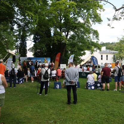 Ludzie uczestniczą w festiwalu Tydzień Kultury Beskidzkiej w parku. (wygenerowano przez AI)