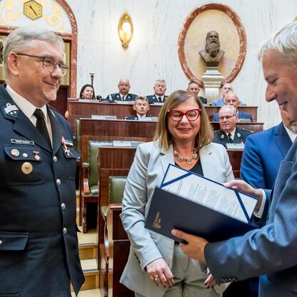 Marszałek Wojciech Saługa wręcza dokument na uroczystości dostawy nowoczesnych wozów ratowniczo-gaśniczych. (wygenerowano przez AI)