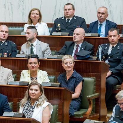 Zgromadzeni w formalnym uroczystości, uczestnicy zapewniają wsparcie dla nowoczesnych wozów strażackich dla OSP w regionie Śląskim. (wygenerowano przez AI)