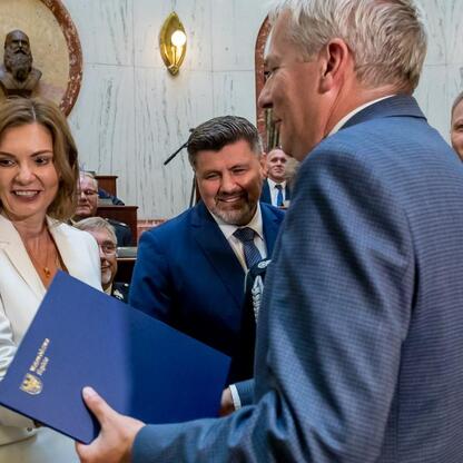 Marszałek Wojciech Saługa i Rafał Adamczyk przekazują dokumenty, symbolizujące transfer nowych wozów strażackich. (wygenerowano przez AI)