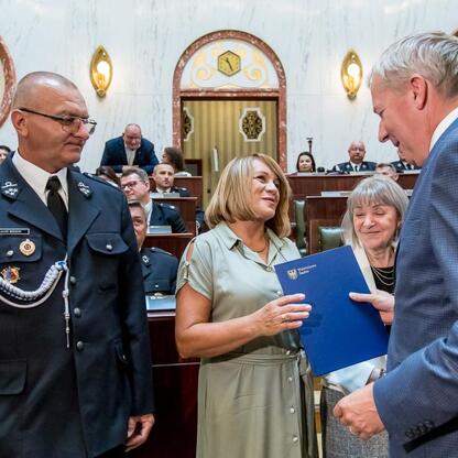 Wojciech Saługa, Marszałek Województwa Śląskiego, wręcza dokument w trakcie ceremonii dostawy nowych wozów ratowniczo-gaśniczych. (wygenerowano przez AI)