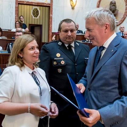 Marszałek Wojciech Saługa prezentuje dokument, symbolizujący transfer obietnicy dotyczącej dostawy nowych wozów strażackich. (wygenerowano przez AI)