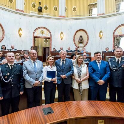 Grupa oficjalna na uroczystości dostawy nowych wozów strażackich w regionie Śląskim. (wygenerowano przez AI)