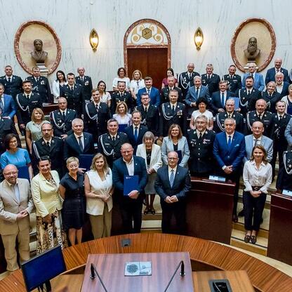 Grupa oficjalna w strojach formalnych na uroczystości dostawy 33 nowoczesnych wozów ratowniczo-gaśniczych do OSP w regionie Śląskim. (wygenerowano przez AI)
