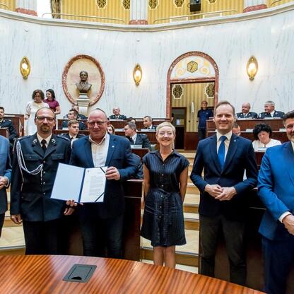 Wojciech Saługa, Marszałek Województwa Śląskiego, uczestniczy w uroczystości wręczenia promes na dofinansowanie zakupu 33 nowoczesnych samochodów ratowniczo-gaśniczych dla OSP w regionie. (wygenerowano przez AI)