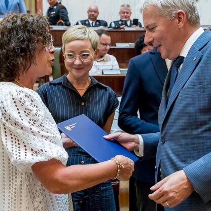 Wojciech Saługa, Marszałek Województwa Śląskiego, wręcza dokument w trakcie ceremonii transferu funduszy na nowe samochody ratowniczo-gaśnicze dla OSP. (wygenerowano przez AI)