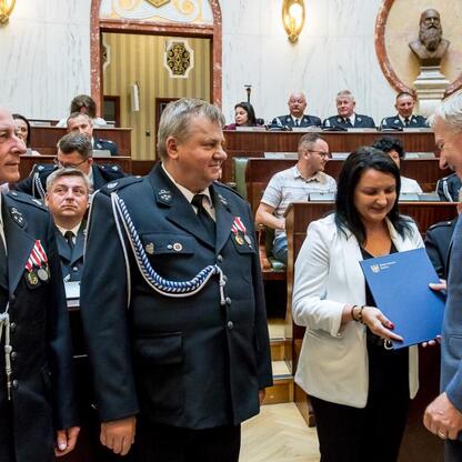 Wojciech Saługa, Marszałek Województwa Śląskiego, wręcza certyfikat w uroczystości dostawy nowych wozów strażackich. (wygenerowano przez AI)