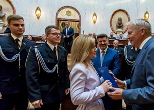 Wojciech Saługa, Marszałek Województwa Śląskiego, wręcza promesy na nowoczesne samochody ratowniczo-gaśnicze OSP. (wygenerowano przez AI)