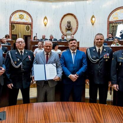 Oficjalna uroczystość przekazania promes na dofinansowanie zakupu nowoczesnych samochodów ratowniczo-gaśniczych dla OSP w regionie Śląskim. (wygenerowano przez AI)