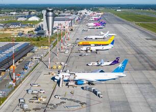 Aerial view of Katowice Airport cargo terminal, showcasing multiple aircraft from DHL, UPS, FedEx, and Star Air, highlighting the bustling cargo operations and significant volume of freight handled. (wygenerowano przez AI)