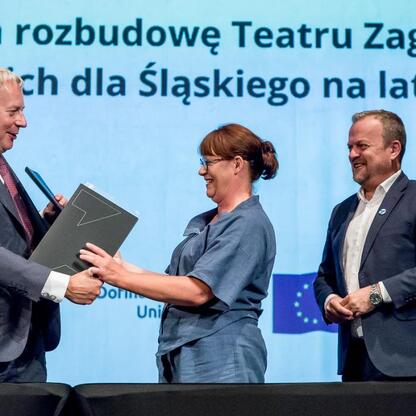 Podpis: Marszałek Wojciech Saługa, prezydent Arkadiusz Chęciński i Anna Jedynak-Rykała podpisują umowę o rozbudowę Teatru Zagłębia w Sosnowcu. (wygenerowano przez AI)