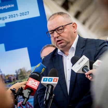 Mężczyzna w garniturze przemawia na konferencji prasowej o funduszach europejskich dla Śląska 2021-2027. (wygenerowano przez AI)