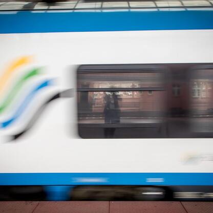 Modern electric train Impulsy 2 in motion at a station, supported by European funds. (wygenerowano przez AI)