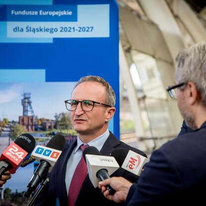 Grzegorz Boski, wicemarszałek Województwa Śląskiego, w rozmowie z dziennikarzami na tle projektu Funduszy Europejskich dla Śląska 2021-2027. (wygenerowano przez AI)