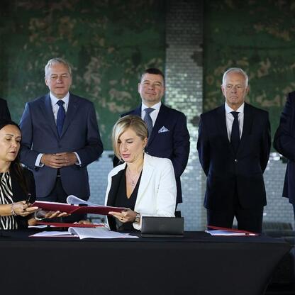 Podpis pod zdjęciem: Formalne podpisywanie dokumentów w ramach inwestycji w nowoczesny hub gamingowo-technologiczny w Katowicach. (wygenerowano przez AI)