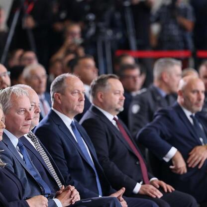 Wojciech Saługa, Marszałek Województwa Śląskiego, oraz Grzegorz Boski, Wicemarszałek Województwa Śląskiego, uczestniczą w ceremonii podpisania umowy na dostawę 180 czołgów K2 dla Wojska Polskiego. (wygenerowano przez AI)