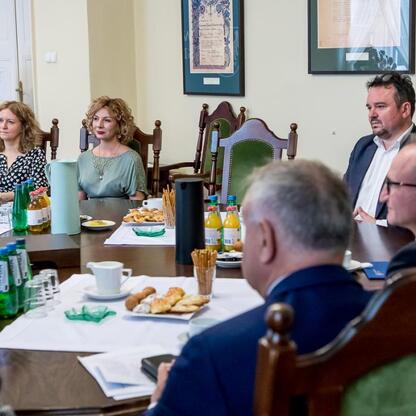 Grzegorz Boski, wicemarszałek województwa śląskiego, prowadzi spotkanie w konferencyjnym pomieszczeniu, gdzie omawiają projekty scalania gruntów w powiatach raciborskim, częstochowskim i zawierciański (wygenerowano przez AI)