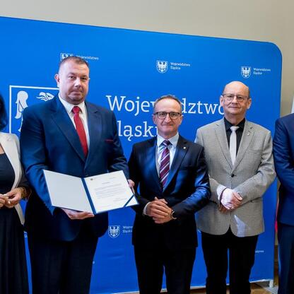 Grzegorz Boski, wicemarszałek Województwa Śląskiego, wręcza listy gratulacyjne, podkreślając sukcesy w scalaniu gruntów w regionie. (wygenerowano przez AI)