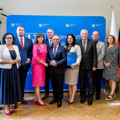 Grzegorz Boski, wicemarszałek województwa śląskiego, wręcza listy gratulacyjne radnym Sejmiku, podkreślając sukcesy w procesie scalania gruntów. (wygenerowano przez AI)