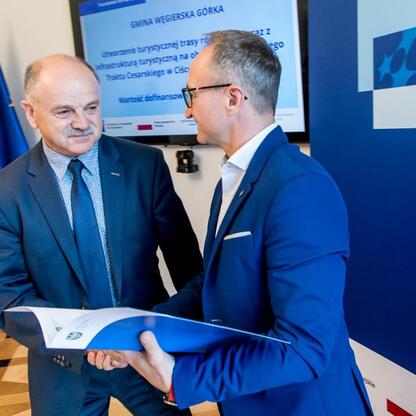 Grzegorz Boski, wicemarszałek Województwa Śląskiego, wręcza listy gratulacyjne przedstawicielom gmin w Sali Błękitnej Gmachu Sejmu Śląskiego. (wygenerowano przez AI)