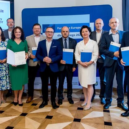 Grzegorz Boski, wicemarszałek Województwa Śląskiego, wraz z grupą oficjalnych osób prezentuje projekty finansowane z Europejskich Funduszy dla Śląska 2021-2027. (wygenerowano przez AI)