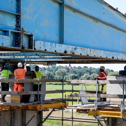 Pracownicy w ochronie bezpieczeństwa montują stalowy girder na mostu nad Odrą w Raciborzu, Polska. (wygenerowano przez AI)
