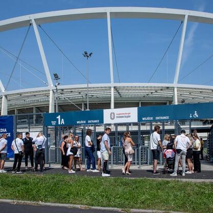 Grupa osób czeka na wejście do Superauto.pl Stadion Śląski, gdzie odbywa się uroczystość nagród za sportowe osiągnięcia. (wygenerowano przez AI)