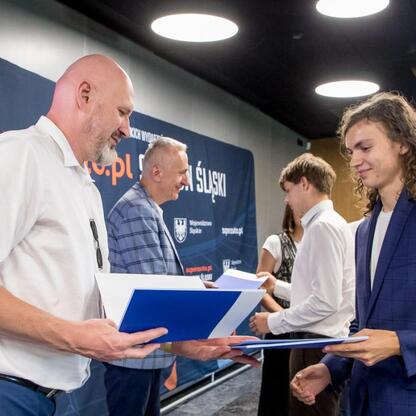 Wicemarszałek Województwa Śląskiego Leszek Pietraszek i Tomasz Majewski wręczają nagrody sportowcom na Superauto.pl Stadion Śląskim. (wygenerowano przez AI)