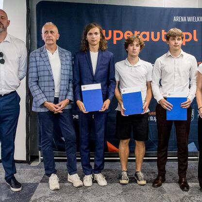 Grupa siedmiu osób otrzymuje nagrody w Superauto.pl Stadionie Śląskim, podczas uroczystości wręczenia Nagród Marszałka Województwa Śląskiego za wybitne osiągnięcia sportowe w 2024 roku. (wygenerowano przez AI)