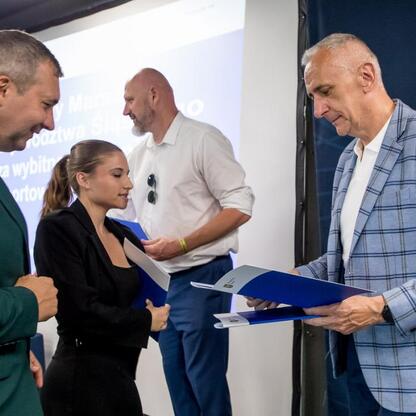 Wicemarszałek Województwa Śląskiego Leszek Pietraszek wręcza nagrodę sportowcom na Superauto.pl Stadion Śląskim. (wygenerowano przez AI)